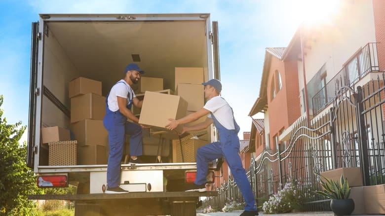 Workers,Unloading,Boxes,From,Van,Outdoors.,Moving,Service
